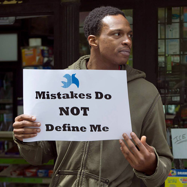 A Fortune participant at an Alternatives to Incarceration (ATI) rally, holding a sign that says "Mistakes Do Not Define Me."