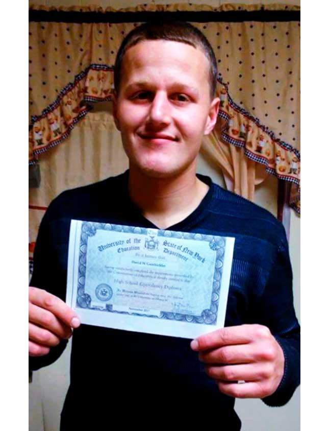 David Gambicher, a reentry program success story, holding up his High School equivalency certificate